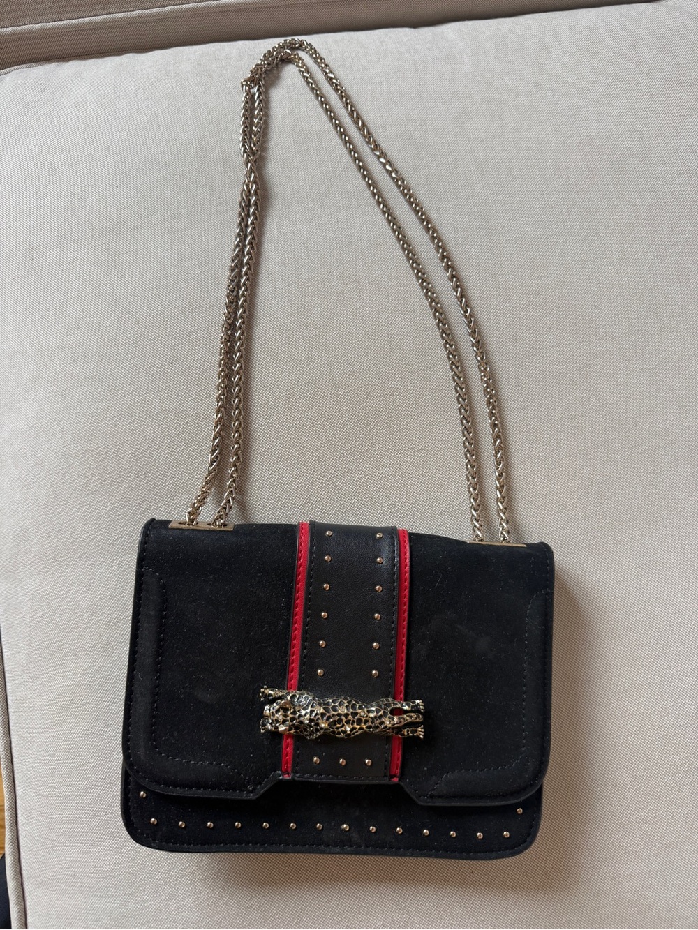 Black Suede Shoulder Bag with Red Accent and Adjustable Gold Chain